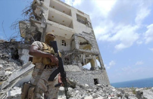 A Saudi soldier stands next to a bombed out building in the port city of Aden in September of 2015. https://flic.kr/p/Gxzq45