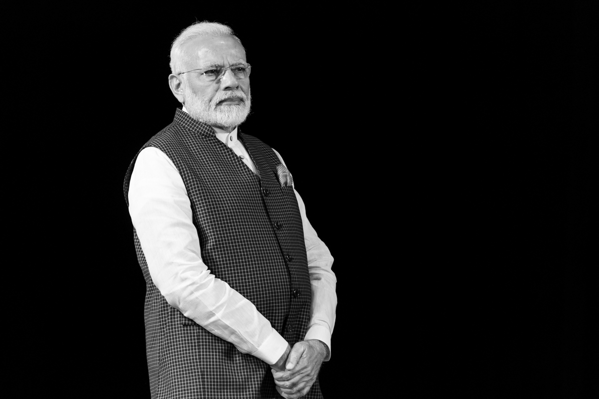Prime Minister Narendra Modi standing against a black background