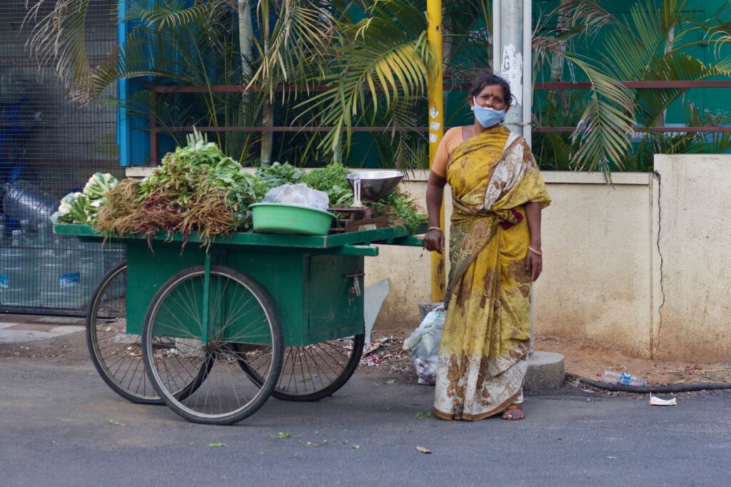 A female street vendor wearing a mask